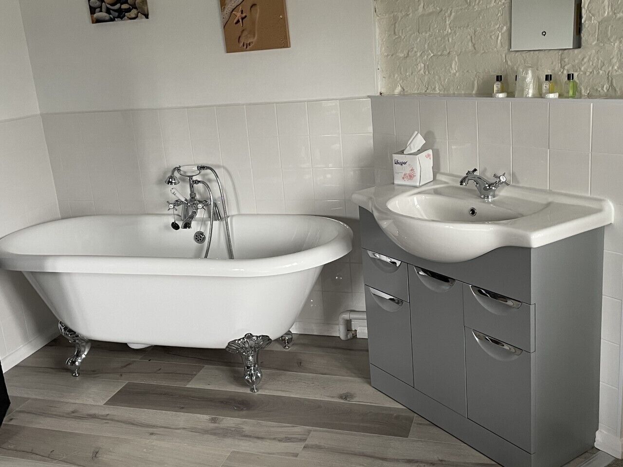 A bathroom with a freestanding bathtub, a sink, and a cabinet.