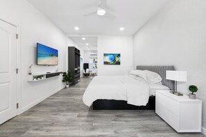 Ein modernes Schlafzimmer mit Bett, Nachttisch und Deckenventilator.
