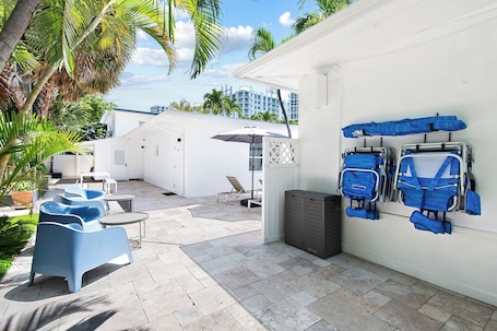 Una piscina al aire libre, sombrillas, sillones reclinables de piscina