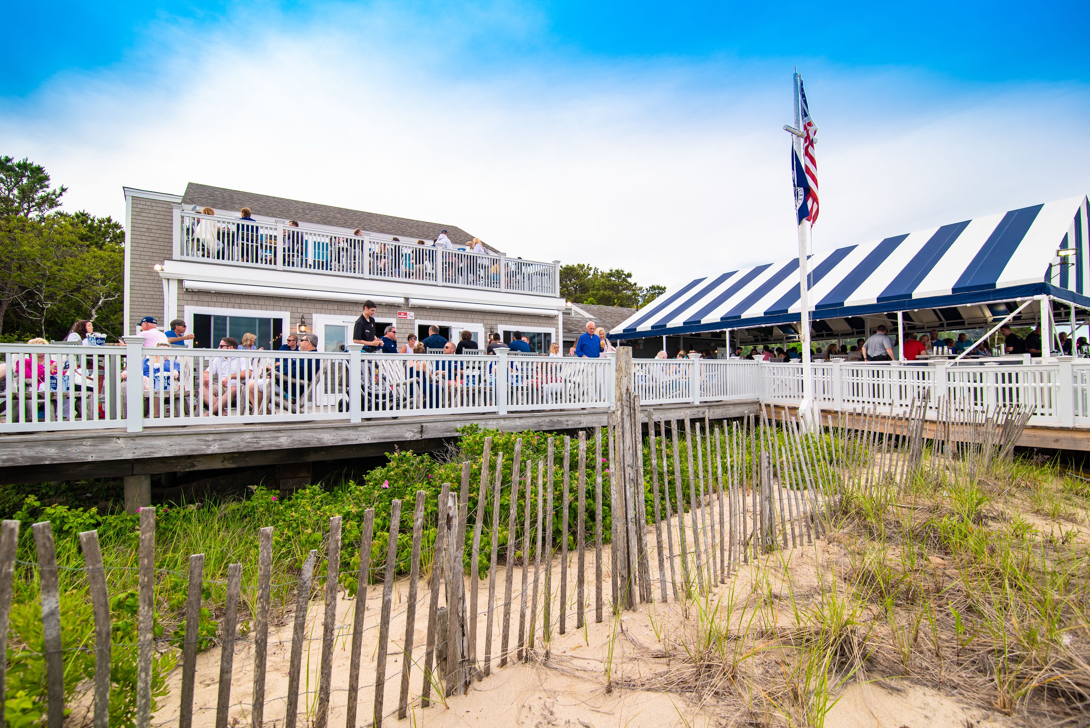 A waterfront building with a deck and a covered area.