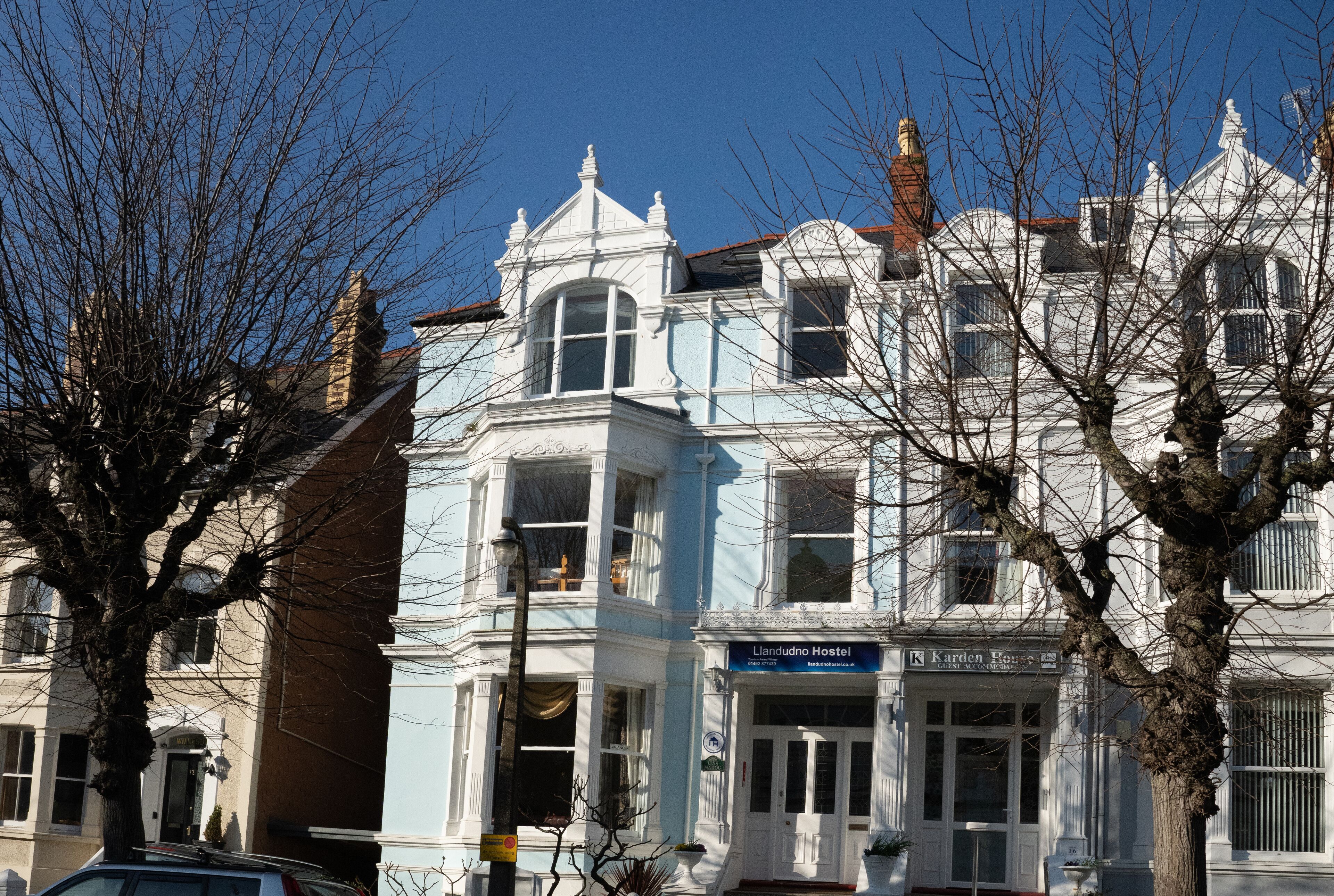 Un edificio histórico con un cartel que indica 'Llandudno Hostel' y 'Karden House'.