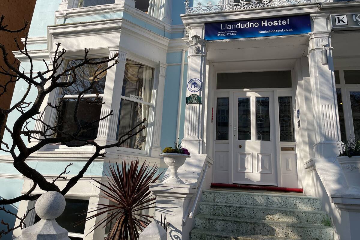 A building with a sign reading "Llandudno Hostel" and a "Tourism Award Winner" badge.