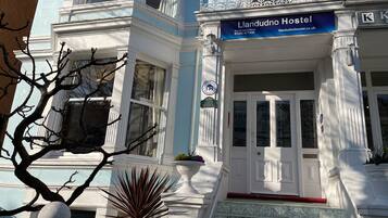 A building with a sign reading "Llandudno Hostel" and a "Tourism Award Winner" badge.