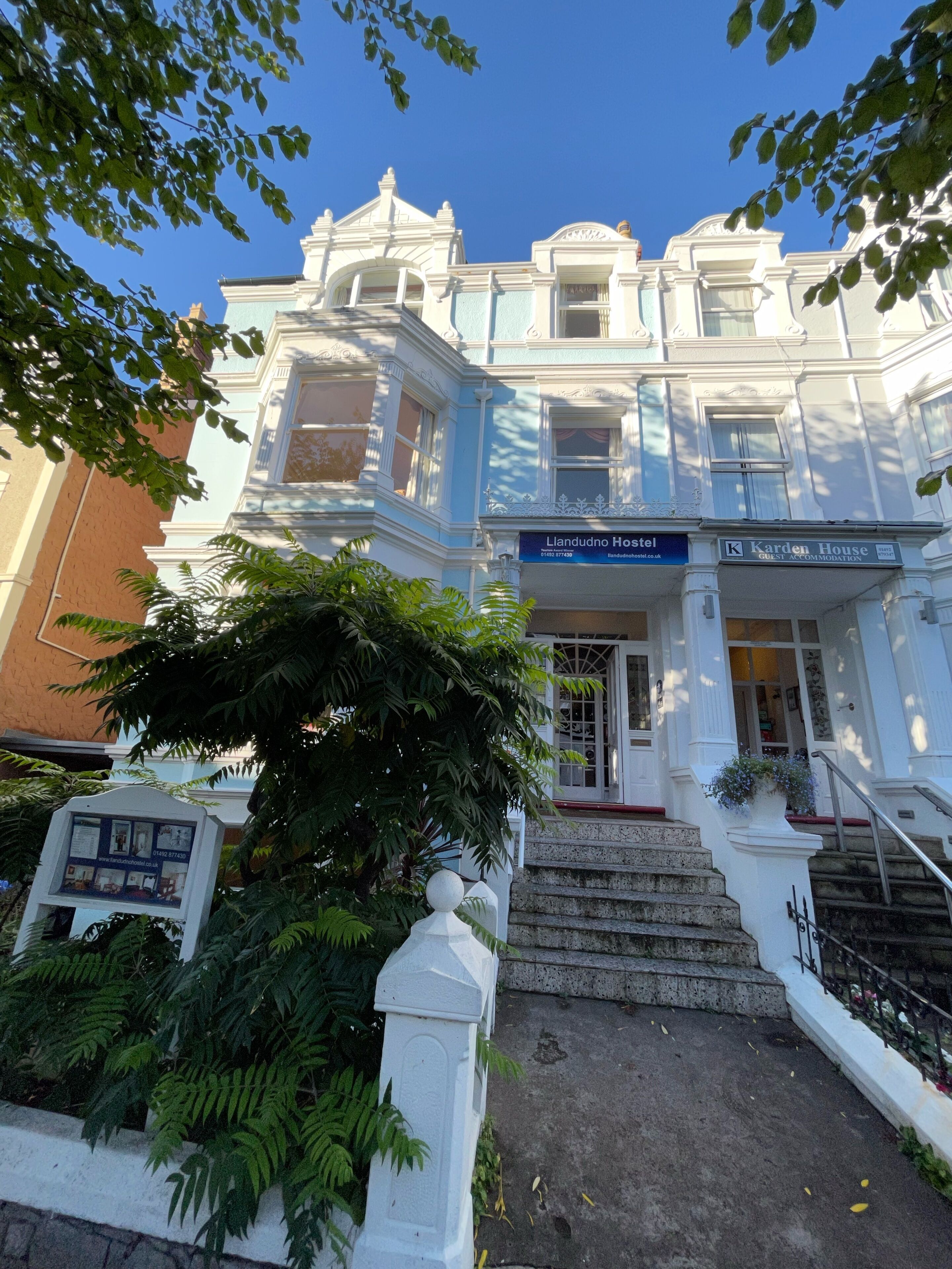 Un bâtiment historique portant une enseigne indiquant « Auberge de Llandudno » et « Karden House », ce qui signale qu’il propose des hébergements pour les clients.