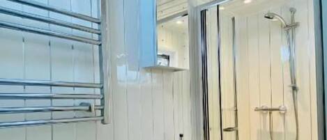 A bathroom with a toilet, sink, and shower area.