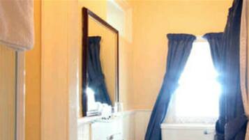 A bathroom with a white sink, a toilet, and a bathtub. There is a blue and white rug on the floor.
