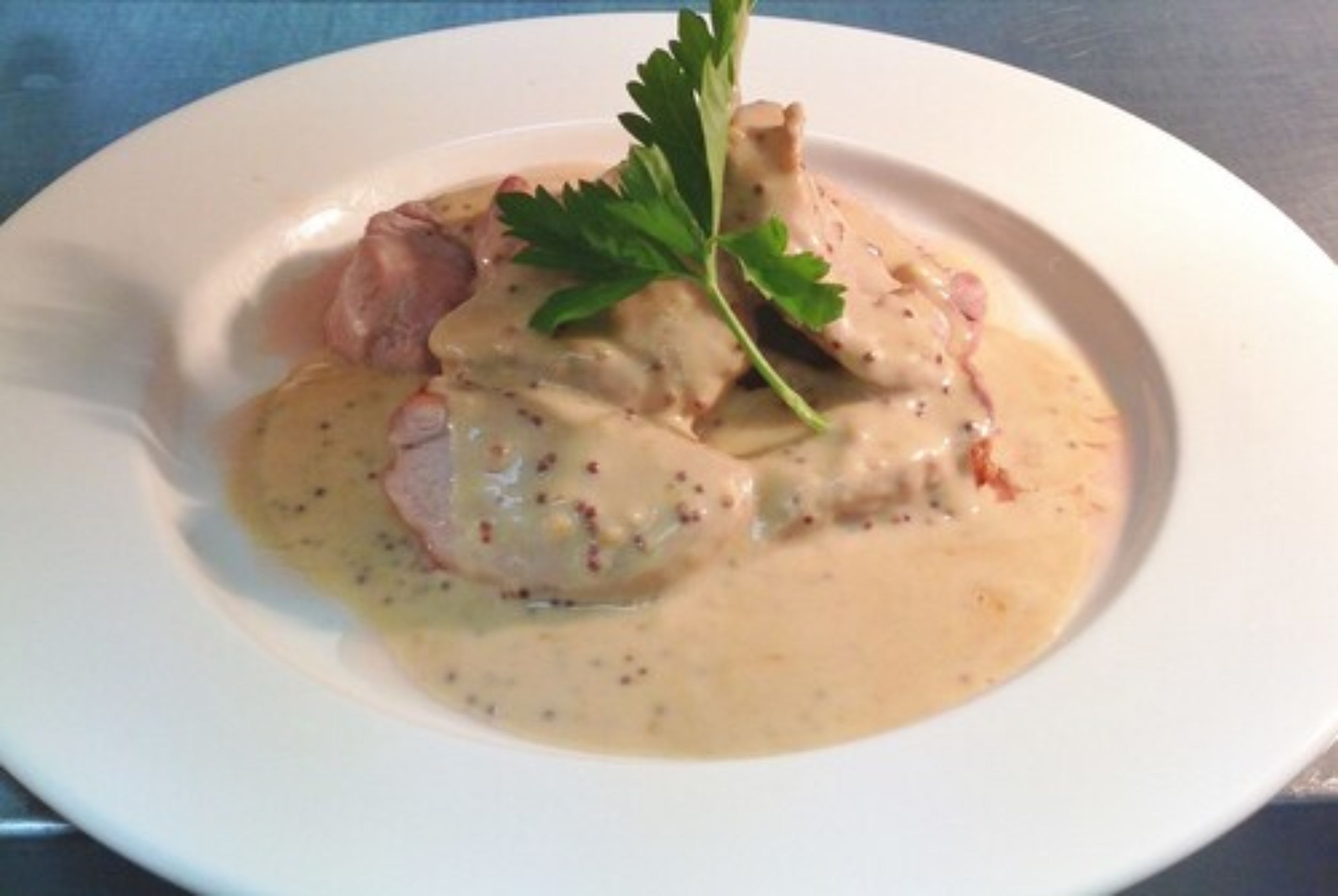 A plate of food with a creamy sauce and a garnish.