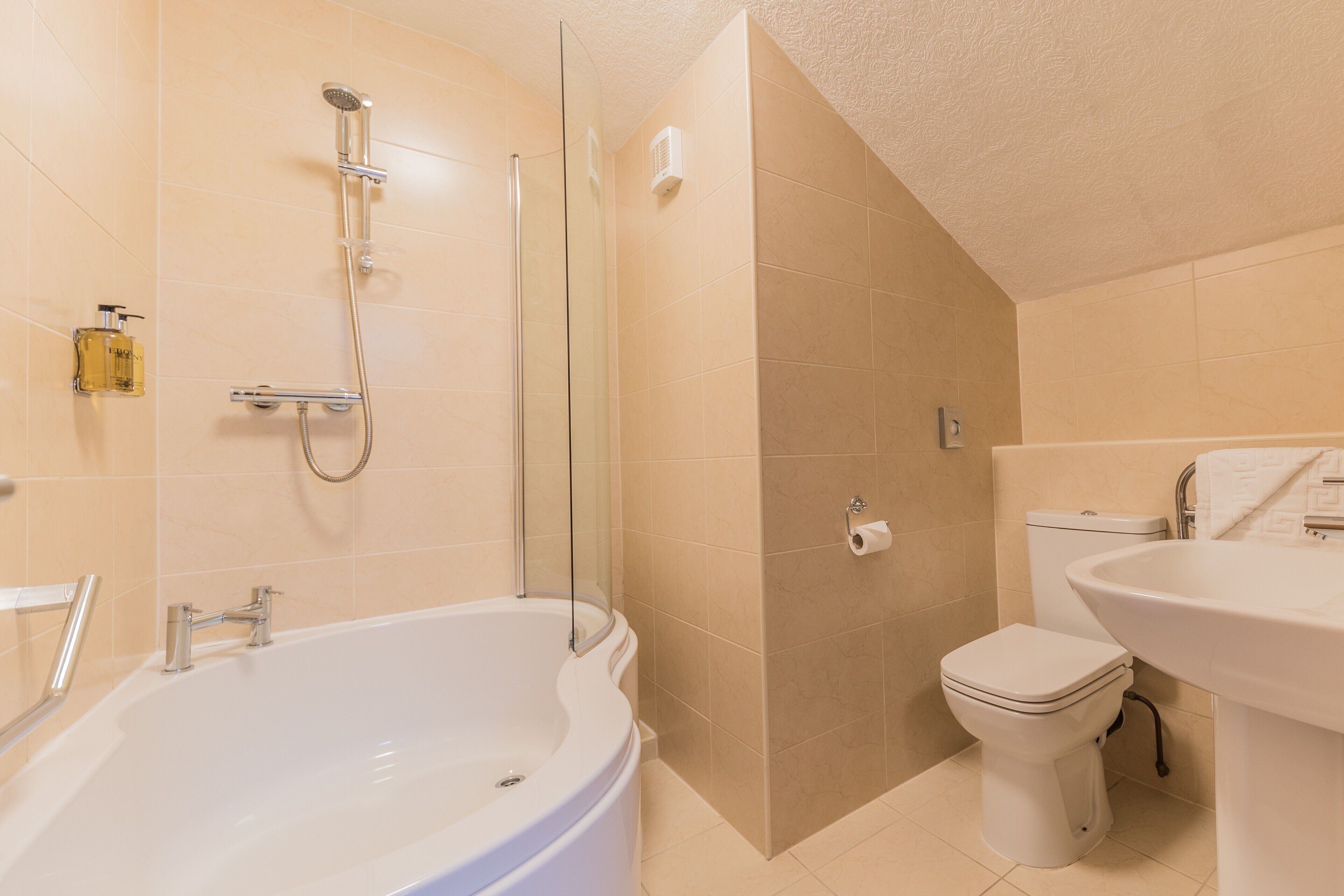 Un baño con bañera, inodoro y ducha.