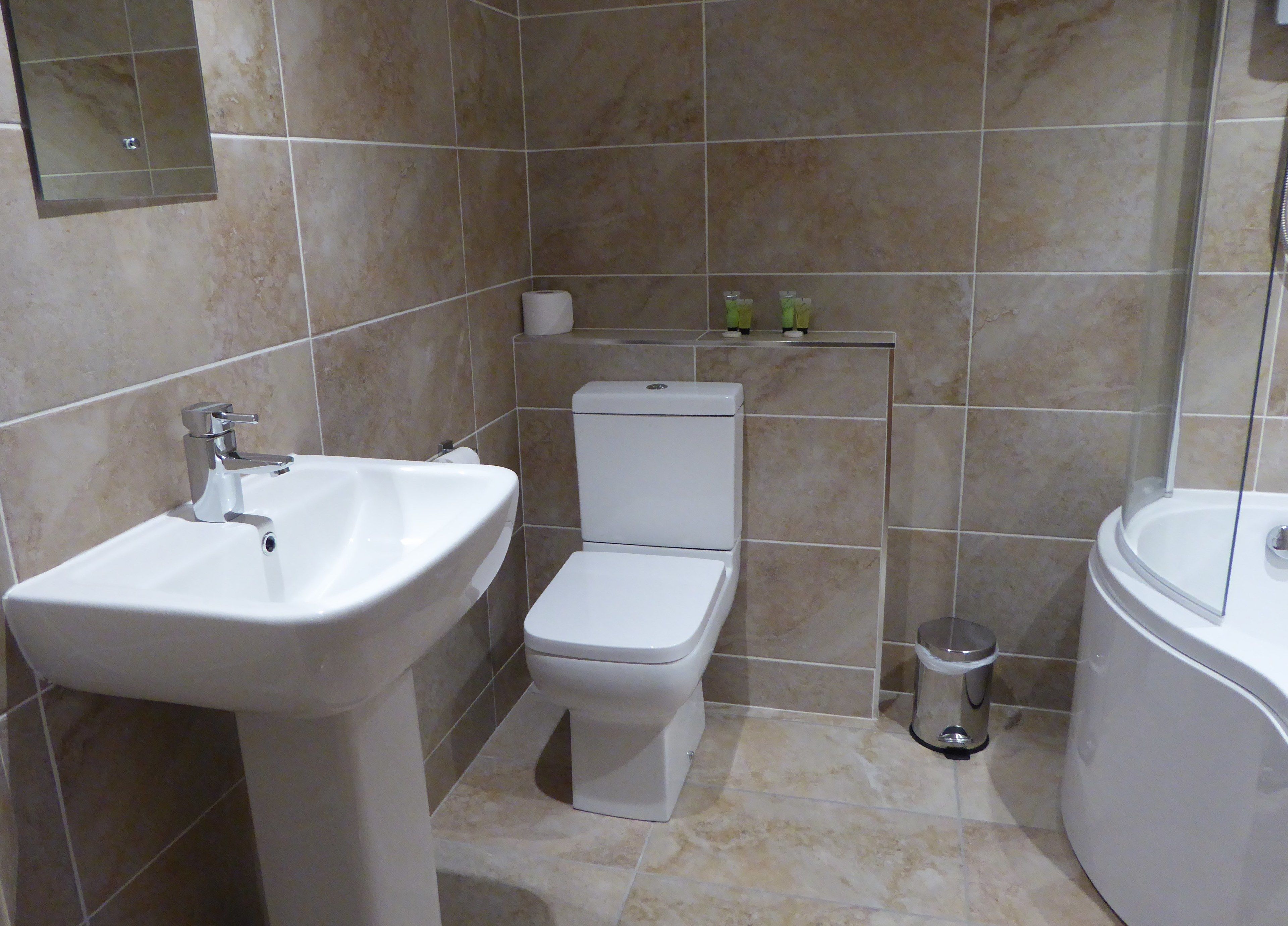 A bathroom with a white sink, toilet, and bathtub.