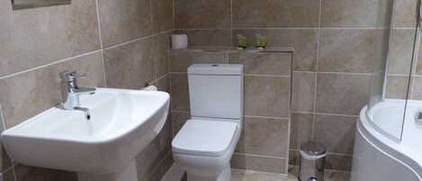 A bathroom with a white sink, toilet, and bathtub.
