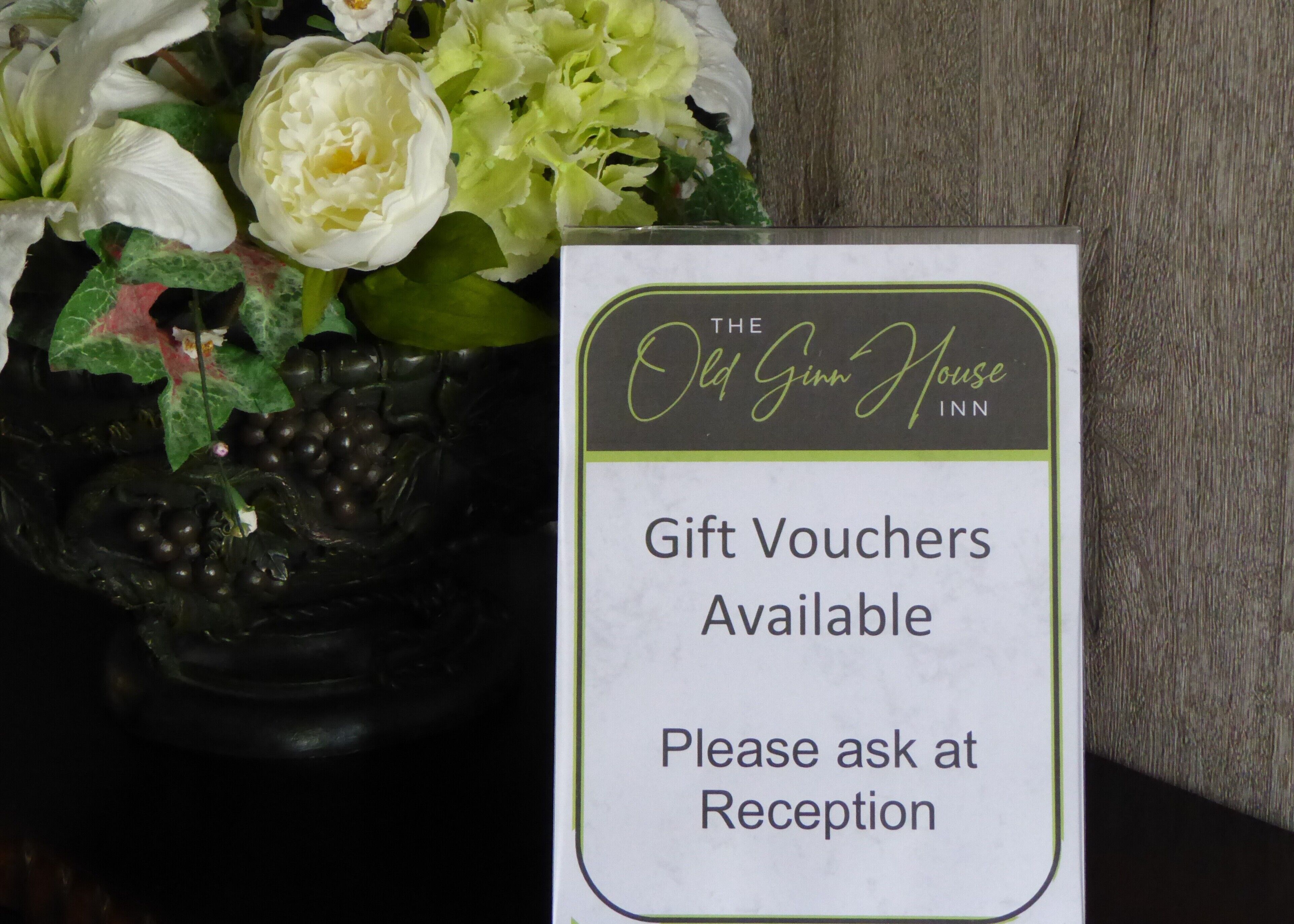 Letrero del Old Gimm House Inn que indica que hay vales de regalo disponibles y que se deben solicitar en recepción.