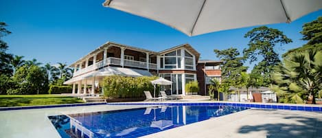 Una piscina al aire libre, sillones reclinables de piscina