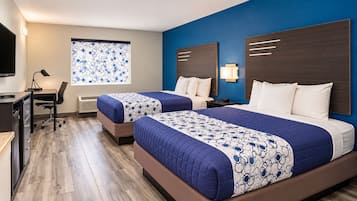 Ein Hotelzimmer mit zwei Betten, einem Schreibtisch und einem Stuhl.