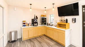 Une cuisine moderne avec des meubles en bois, un plan de travail en marbre et des luminaires suspendus.