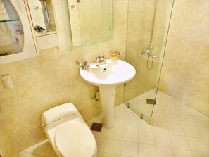 A bathroom with a toilet, sink, and shower. - Palm Hill Pension (Seogwipo)
