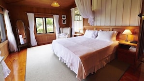 Un dormitorio con una cama grande, techo de madera y dosel.