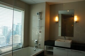 Een moderne badkamer met een douchecabine van glas, een witte wastafel en een grote spiegel.