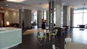 Un hall d’entrée spacieux doté d’un grand espace salon, d’une fontaine centrale et de grandes fenêtres laissant entrer la lumière naturelle.