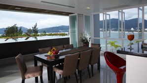 A modern dining area with a view of a lake and mountains. - Jirana Patong (Patong)