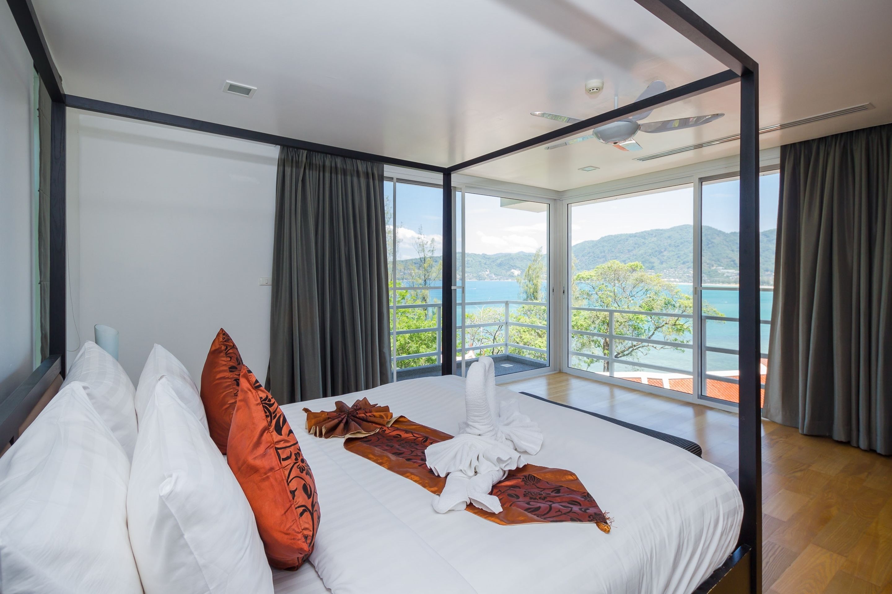Ein modernes Hotelzimmer mit einem großen Bett, Meerblick und einem Balkon.