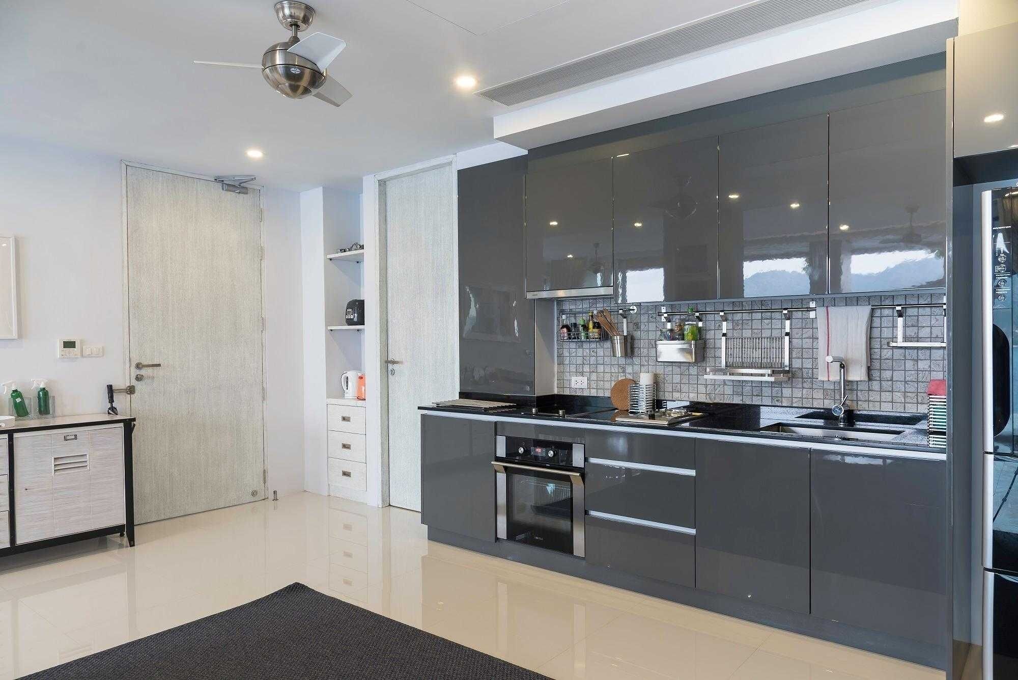 A modern kitchen with a built-in oven, a dishwasher, and a large island with a sink.