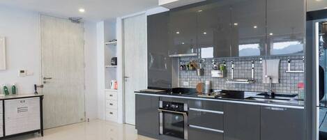 A modern kitchen with a built-in oven, a dishwasher, and a large island with a sink.