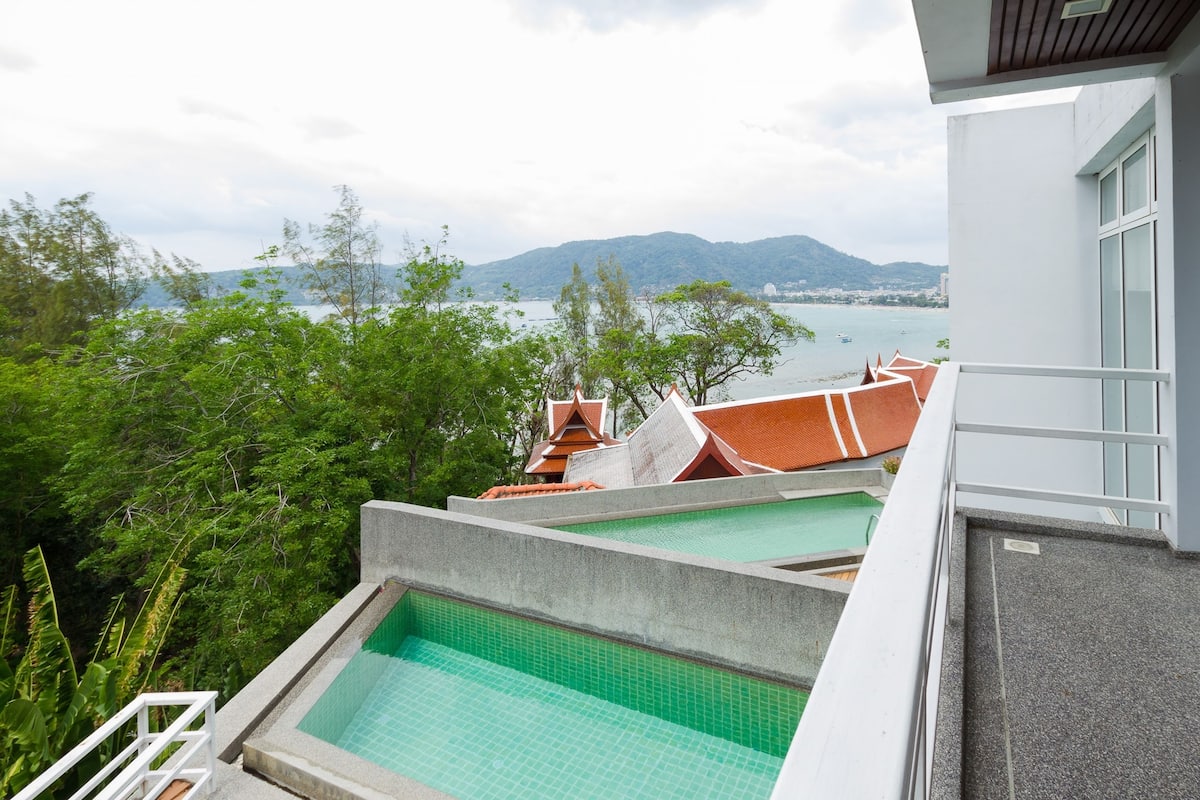 A view of a swimming pool with a mountain and lake in the background.