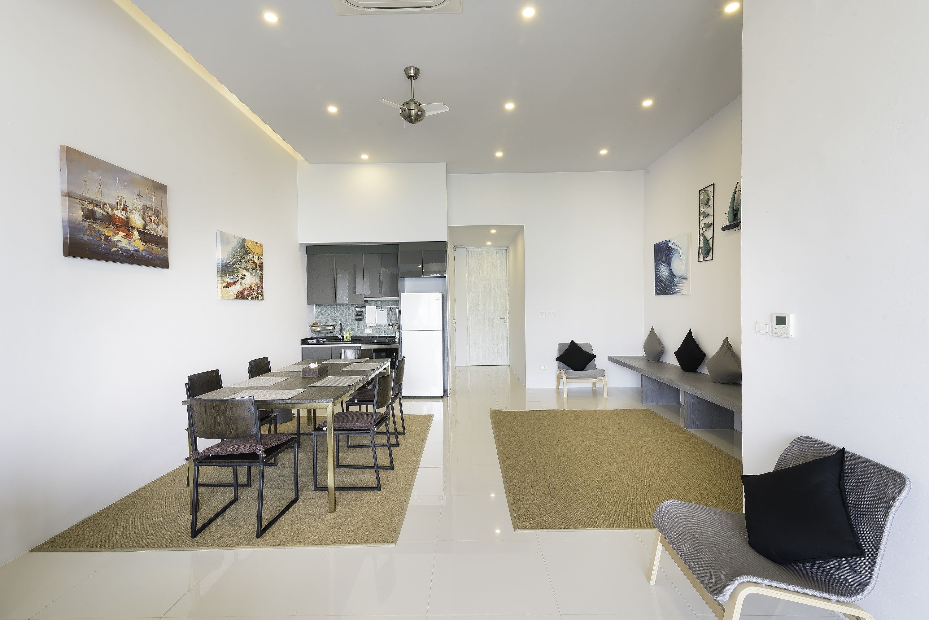 A modern living space with a dining area, kitchen, and seating area.