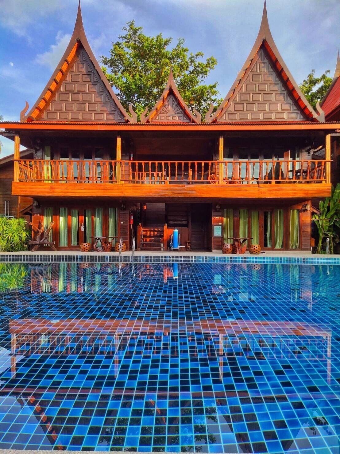 A traditional building with a large pool in front.