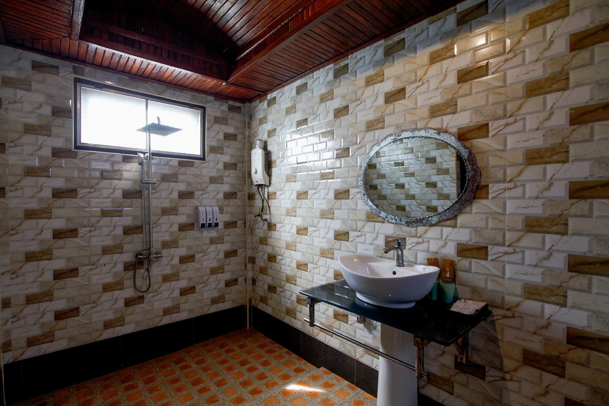 Une salle de bain avec une douche, un lavabo, un miroir et une fenêtre.