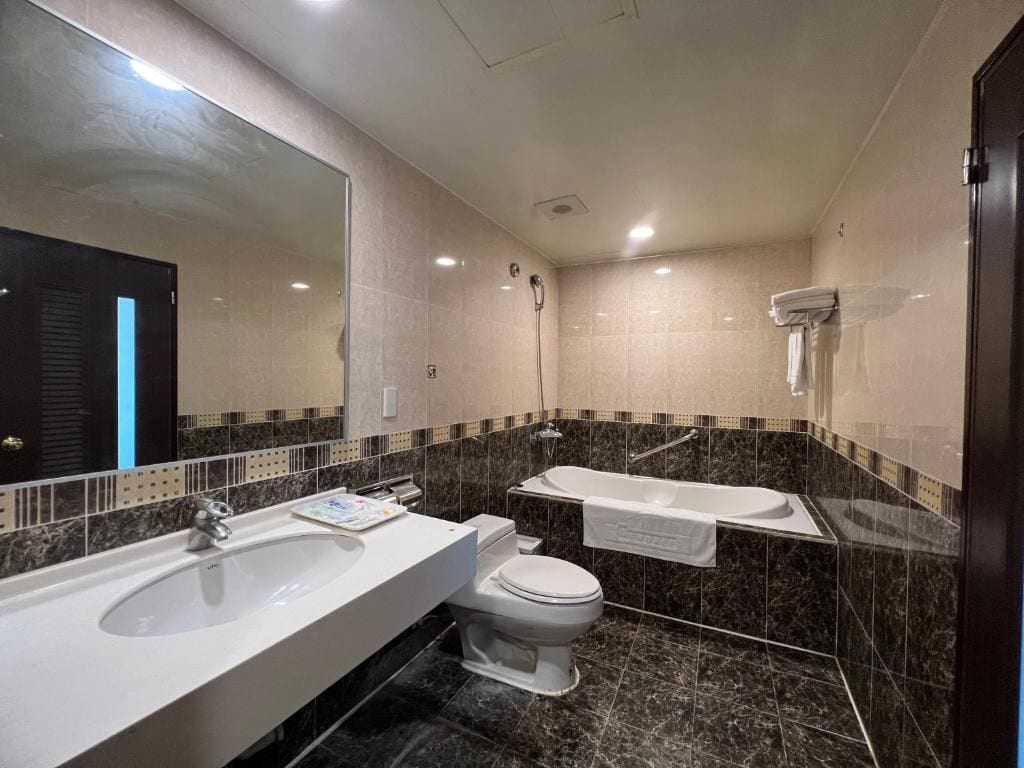 Un baño moderno con un lavamanos grande, inodoro y bañera.