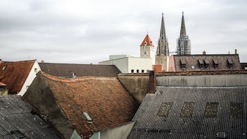 A view of a cityscape with historic buildings, including a church with twin spires and a building under construction.