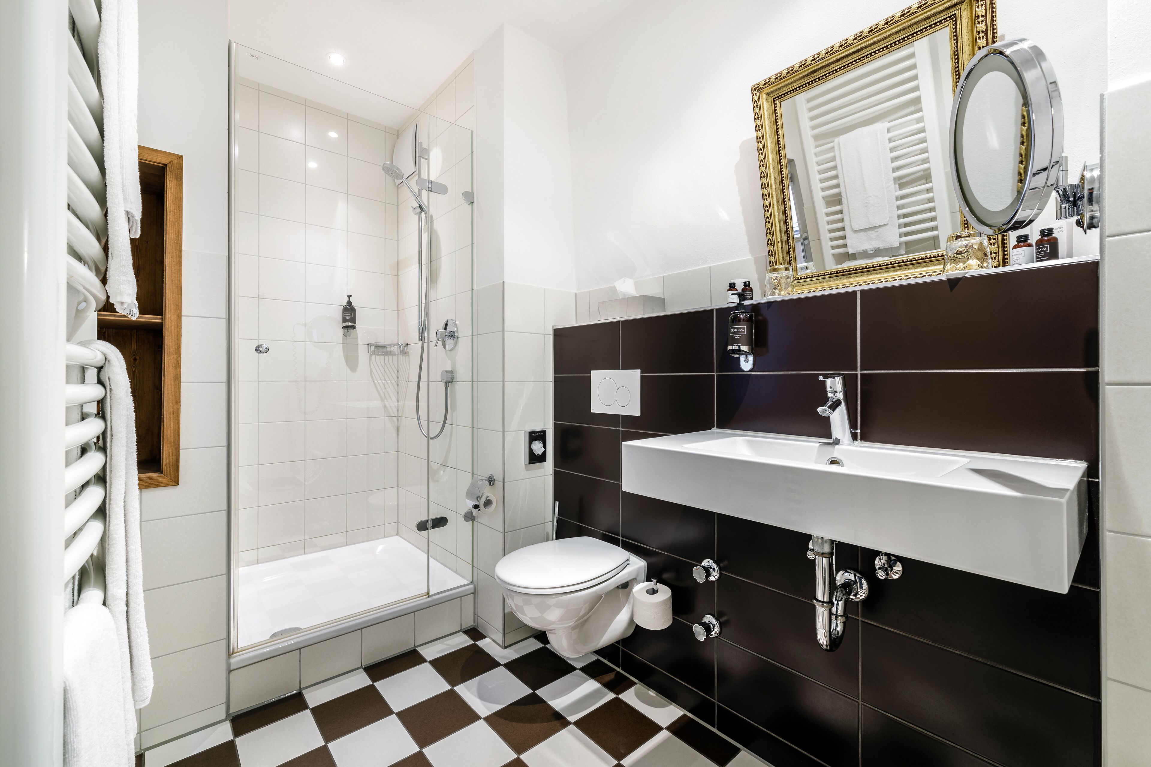 A modern bathroom with a glass-enclosed shower, a white toilet, and a black and white checkered floor.