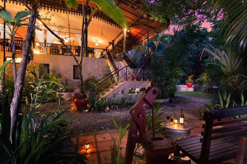 An outdoor patio area with a wooden bench, a fire pit, and potted plants.