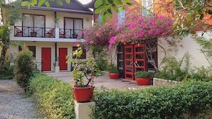 A two-story building with a balcony, a red door, and potted plants. - The Cockatoo Nature Resort & Spa (Siem Reap)
