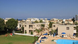 Zona residencial con piscina, varios edificios y vista despejada al mar.
