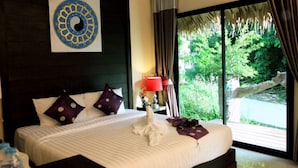 Habitación de hotel con una cama grande, una obra de arte colgada en la pared, una ventana con cortinas y vista a zonas verdes.