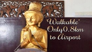 A statue with a plaque stating "Walkable Only 0.8km to Airport". - DMK Hostel Donmueang Airport (Bangkok)