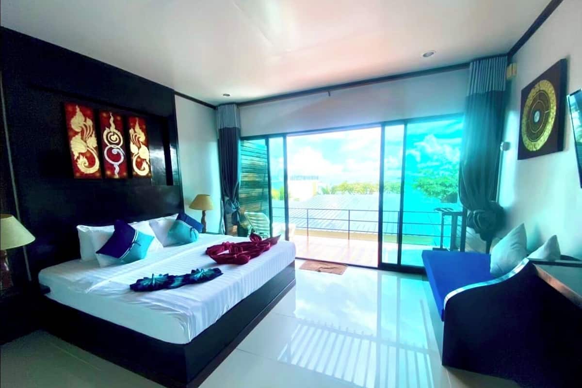 A modern hotel room with a large bed, a balcony with a view, and a large window.