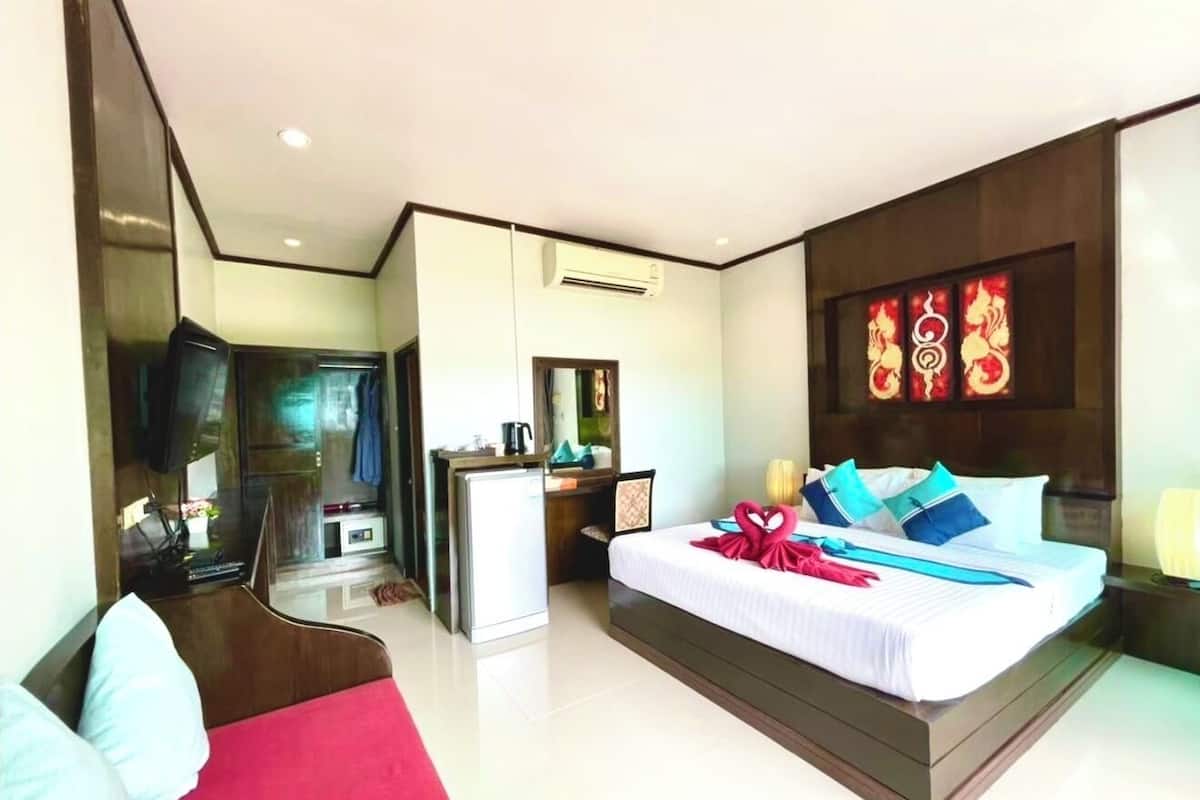 A modern hotel room with a large bed, a desk, and a TV.