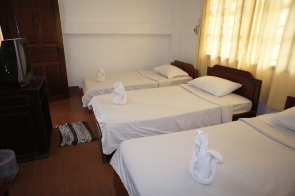 A hotel room with three single beds, a wooden wardrobe, and a television on a wooden stand. - Malany Villa 1 (Vang Vieng)
