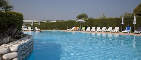 Piscine couverte, piscine extérieure, parasols de plage, chaises longues