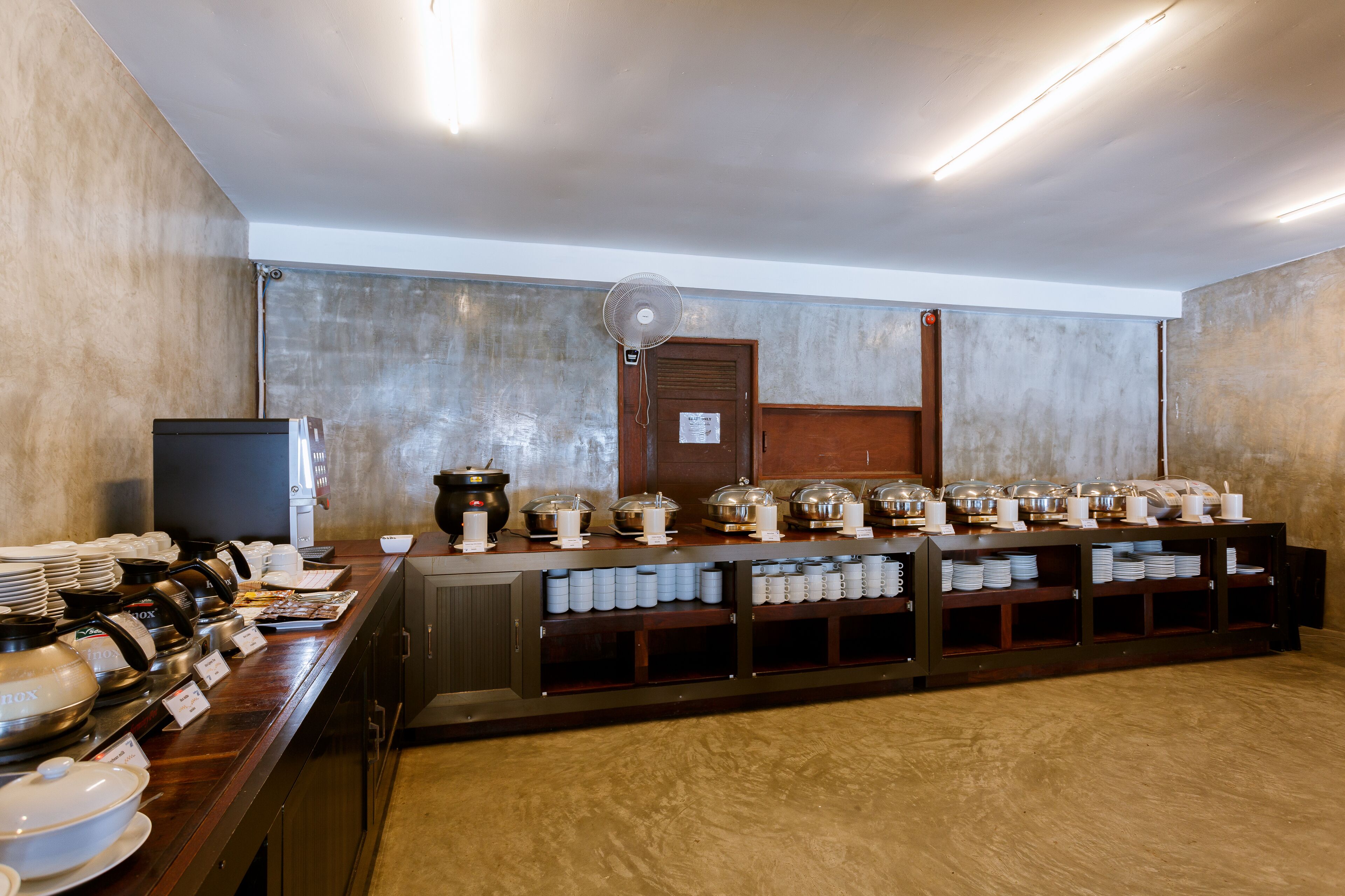 A buffet setup with various food containers and utensils.