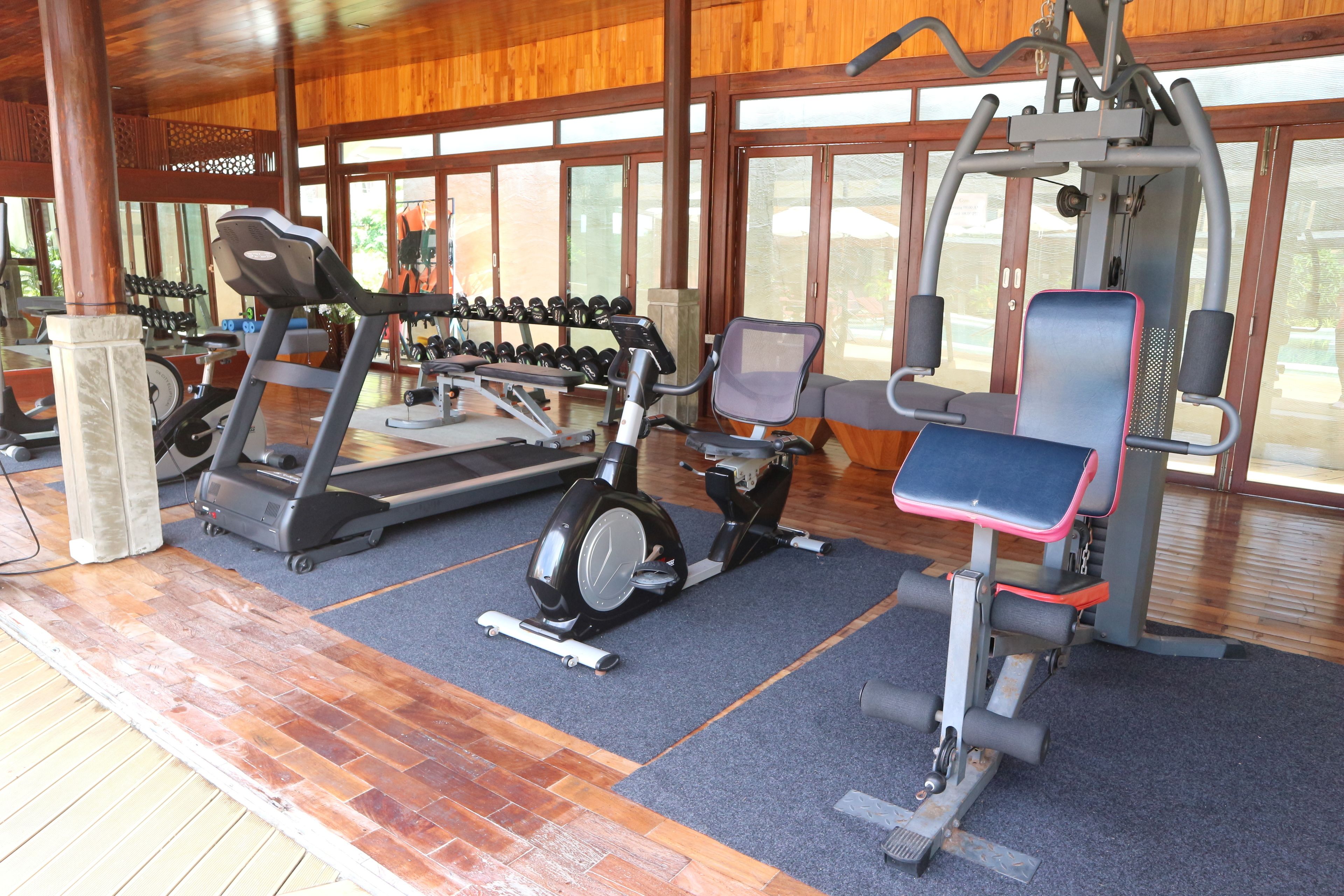 Un gimnasio con cintas de correr, elípticas y pesas sueltas.