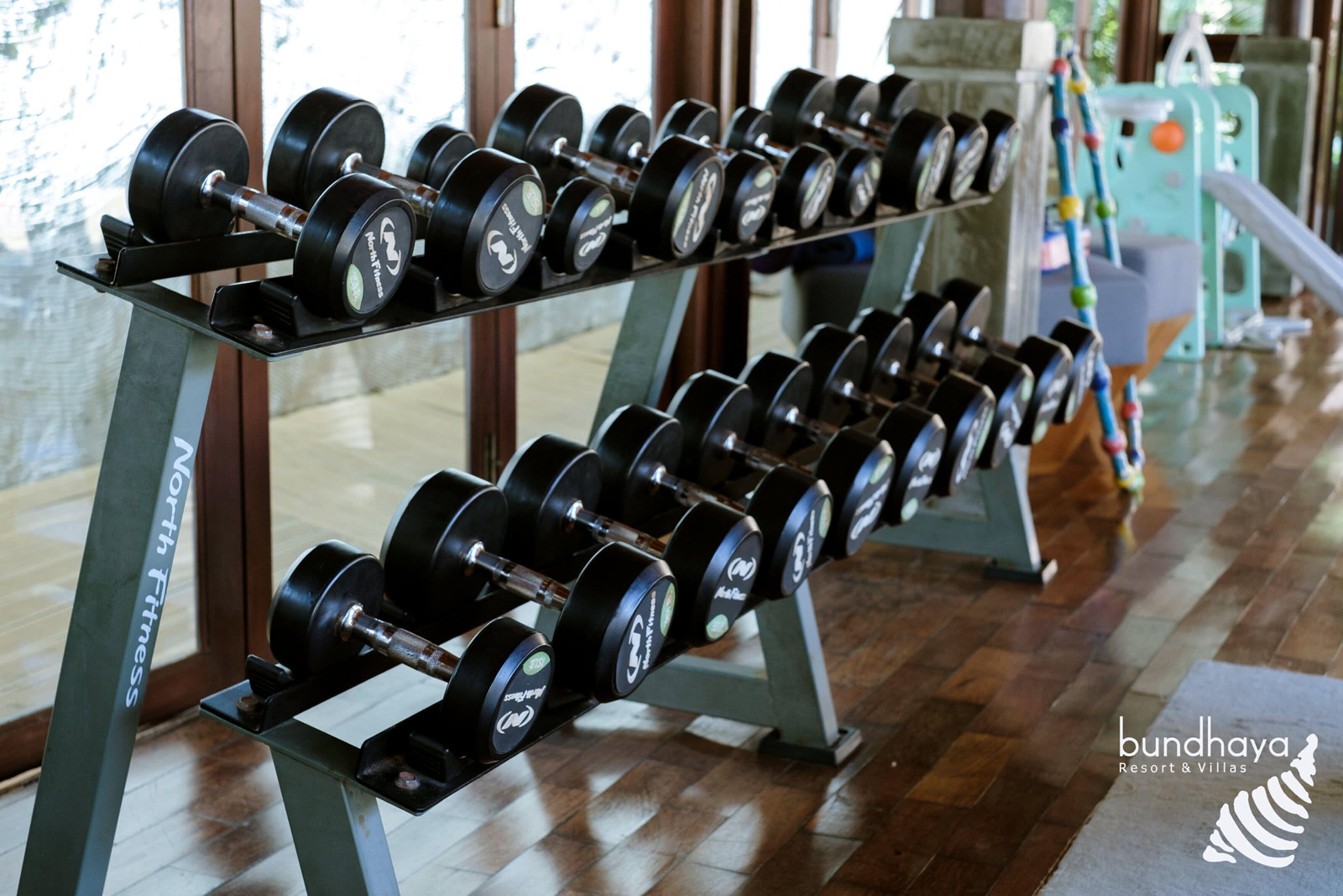 A gym with rows of dumbbells on stands.