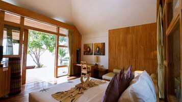 A spacious room with a large bed, wooden furniture, and a view of the outdoors.