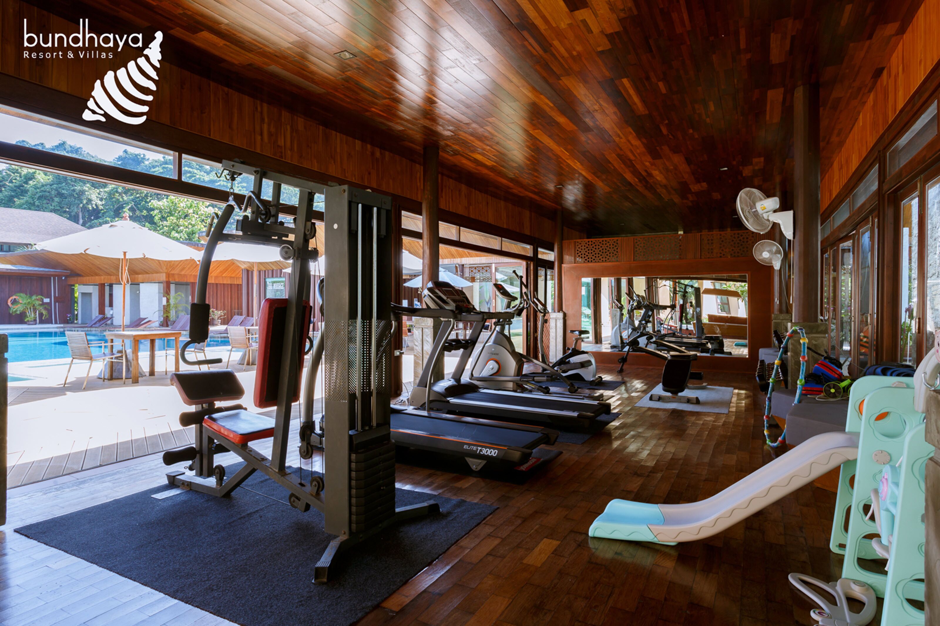 A gym with treadmills, weight machines, and a slide.