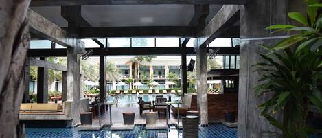 A modern indoor pool area with clear views of a hotel building in the background.