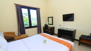 A hotel room with a bed, a desk, a chair, a TV, and a window with curtains. - The Star Hill Hotel (Balikpapan)