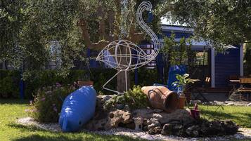 Relax in a serene garden oasis with a unique metal sculpture and lush greenery.